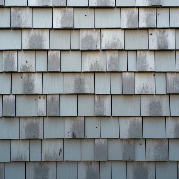 Overlapping weathered cedar shingles with silvered grain and irregular butt edges