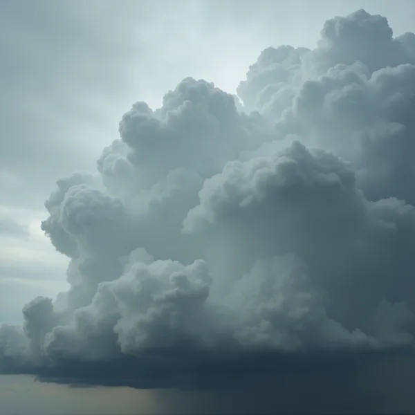 A dense towering bank of grey storm cloud with deep soft internal shadow